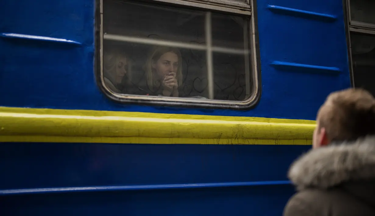 Bogdan, 41, mengucapkan selamat tinggal kepada istrinya Lena, 35, di kereta api menuju Lviv di stasiun Kiev, Ukraina, 3 Maret 2022. Bogdan tinggal untuk mempertahankan negaranya sementara keluarganya meninggalkan Ukraina mencari perlindungan di negara- negara tetangga. (AP Photo/Emilio Morenatti)