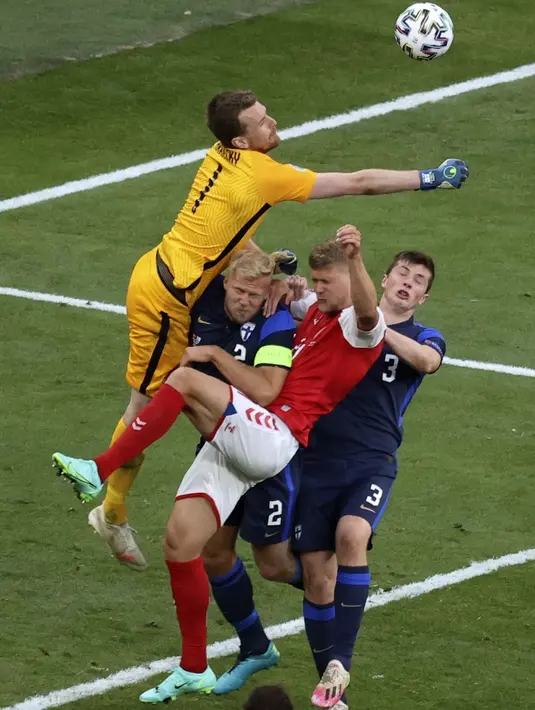 Kiper timnnas Finlandia, Lukas Hradecky meninju bola pada laga Grup B Euro 2020 kontra Denmark di Parken Stadium, Sabtu (12/6/2021). Selain tumbang 0-1, tuan rumah juga terpukul menyusul insiden yang melibatkan Christian Eriksen. (Wolfgang Rattay/Pool via AP)