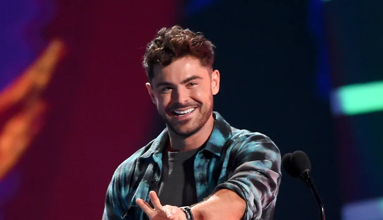 Aktor Zac Efron menerima penghargaan pada acara Teen Choice Awards di California, 12 Agustus 2018. Tak hanya mencuri perhatian dengan tampilannya, rupanya Zac juga sukses memboyong sejumlah piala. (Kevin Winter/Getty Images/AFP)