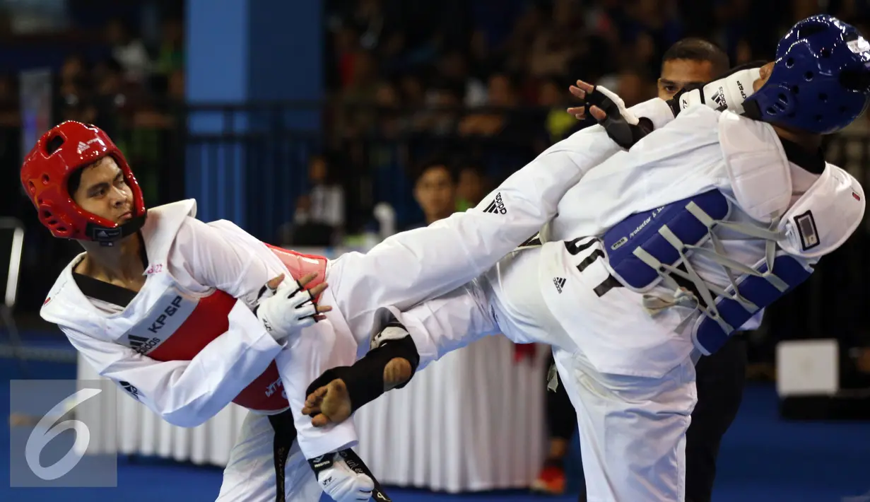 Taekwondoin Jawa Barat, Dinggo (kiri) melakukan tendangan ke arah pemain DIY, Okky Indera P saat laga final kelas -68kg PON XIX di Gymnasium UPI, Bandung, Senin (26/9/2016). Dinggo meraih emas setelah unggul 16-4. (Liputan6.com/Helmi Fithriansyah)