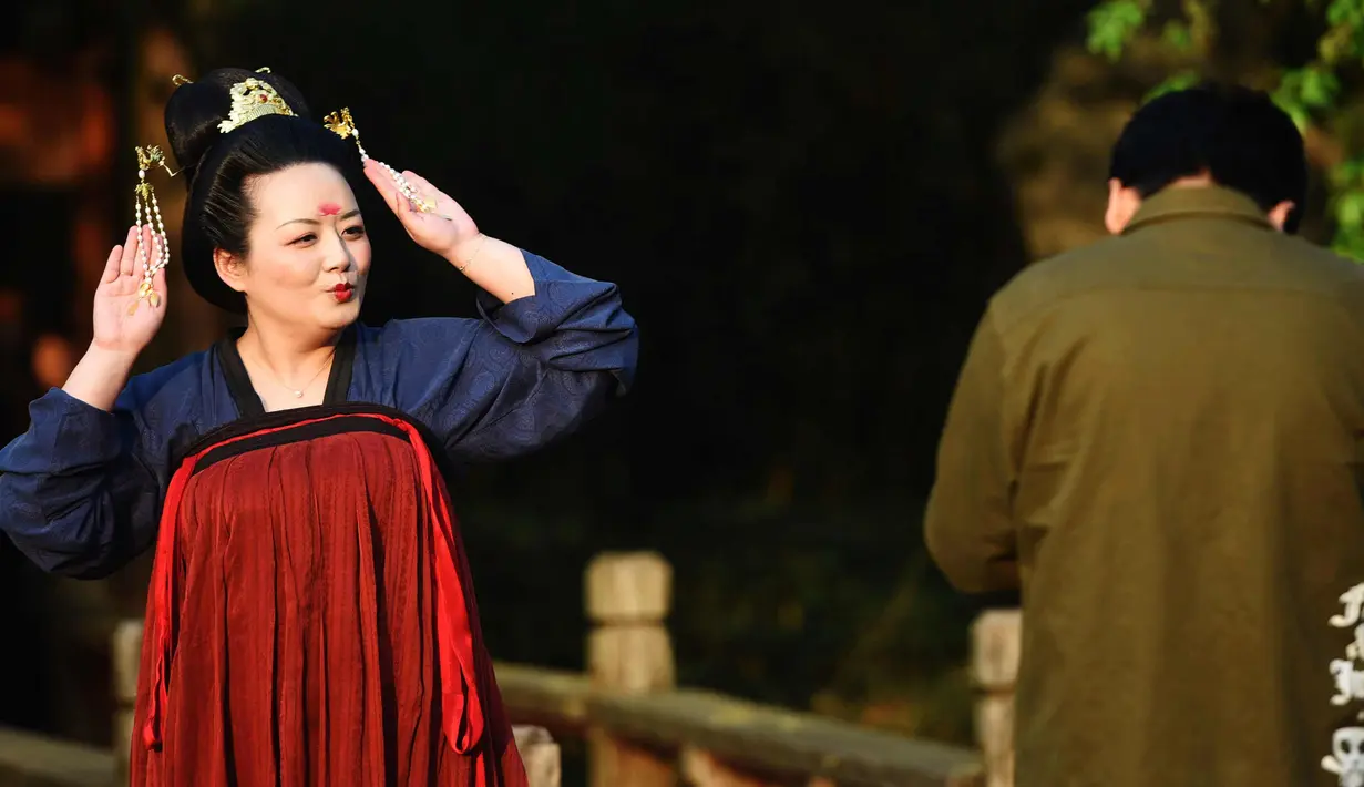 Seorang wanita mengenakan kostum Dinasti Tang berpose saat ia mengunjungi Danau Barat di Hangzhou di provinsi Zhejiang timur China (31/3). Kostum Dinasti Tang memiliki Struktur alami, anggun dan elegan, dan aksesoris yang indah. (AFP Photo/China Out)