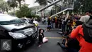 Model berpose di depan sebuah mobil saat fotograper melakukan pemotretan di Jalan MH Thamrin, Jakarta, Minggu (19/7/2015). Momen Jakarta sepi akibat banyak yang mudik, dimanfaatkan fotografer untuk memotret model. (Liputan6.com/Johan Tallo)