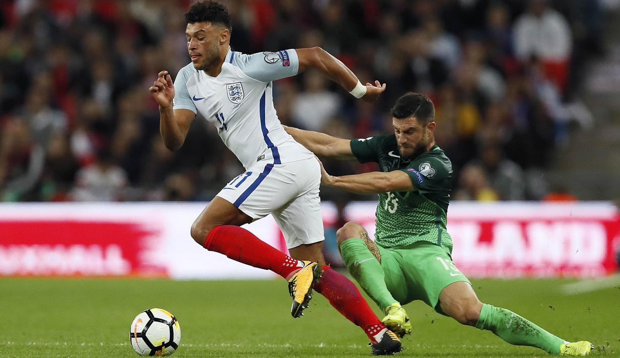 Gelandang Inggris, Alex Oxlade-Chamberlain, berebut bola dengan bek Slovenia,  Bojan Jokic, pada laga Kualifikasi Piala Dunia 2018 di Stadion Wembley, Kamis (5/10/2017). Inggris menang 1-0 atas Slovenia. (AP/Kirsty Wigglesworth)