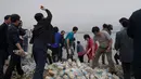 Aktivis pembelot Korea Utara melemparkan botol berisi beras, uang dan USB  ke laut dari pulau Ganghwa, barat Seoul, Selasa (1/5). Mereka telah melempar ratusan botol informasi tersebut dua kali sebulan selama lebih dari dua tahun terakhir. (AFP/ED JONES)