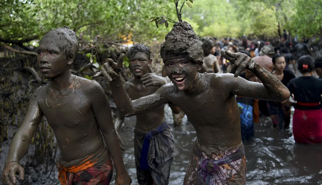 Orang-orang mengambil bagian dalam tradisi mandi lumpur yang dikenal sebagai Mebuug-buugan di Desa Kedonganan, Bali, 4 Maret 2022. Mebuug-buugan diadakan sehari setelah Nyepi yang bertujuan untuk menetralkan sifat buruk. (SONY TUMBELAKA/AFP)