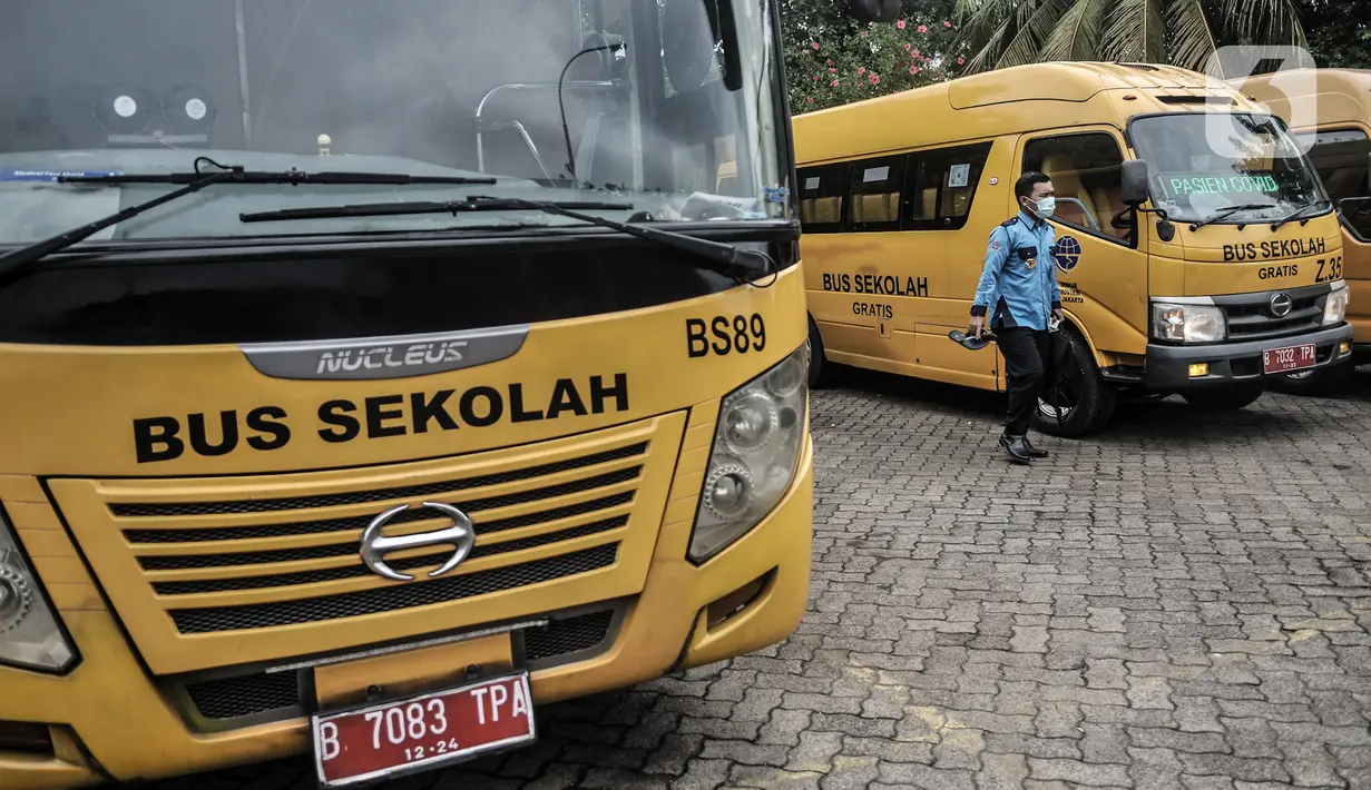 Salah satu sopir turun dari bus sekolah usai melakukan dekontaminasi di Pool Unit Pelayanan Angkutan Sekolah (UPAS) DKI Jakarta, Kramat Jati, Selasa (5/1/2021). Usai bertugas mengantarkan pasien Covid-19, para sopir bus sekolah tersebut rutin melakukan dekontaminasi. (merdeka.com/Iqbal Nugroho)