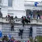 Massa pendukung Presiden Amerika Serikat Donald Trump memanjat dinding barat Capitol Hill, Washington, Amerika Serikat, Rabu (6/1/2021). Wanita yang ditembak di dalam Gedung Capitol Hill selama kerusuhan Rabu 6 Januari 2021 sore dinyatakan meninggal di sebuah rumah sakit. (AP Photo/Jose Luis Magana)