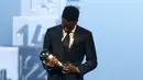 Pemain Real Madrid, Vinicius Jr memandang trofi penghargaan pemain pria terbaik FIFA 2024 dalam acara yang berlangsung di oha, Qatar pada Selasa (18/12) malam waktu setempat. (AP Photo/Hussein Sayed)