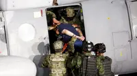 Tentara Meksiko mengawal gembong narkoba Joaquin "El Chapo" Guzman naik ke helikopter sebelum memberikan keterang kepada media di Mexico City, (8/1/2016). (REUTERS/Tomas Bravo)