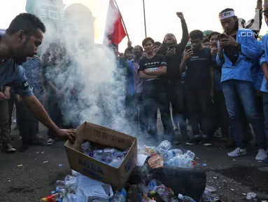 Mahasiswa dari berbagai kampus membakar botol plastik saat menggelar demonstrasi di Gedung DPR/MPR, Jakarta, Kamis (19/9/2019). Mahasiswa menolak Revisi Kitab Undang-Undang Hukum Pidana (RKUHP) dan Undang-Undang Komisi Pemberantasan Korupsi (UU KPK) yang baru disahkan. (Liputan6.com/JohanTallo)