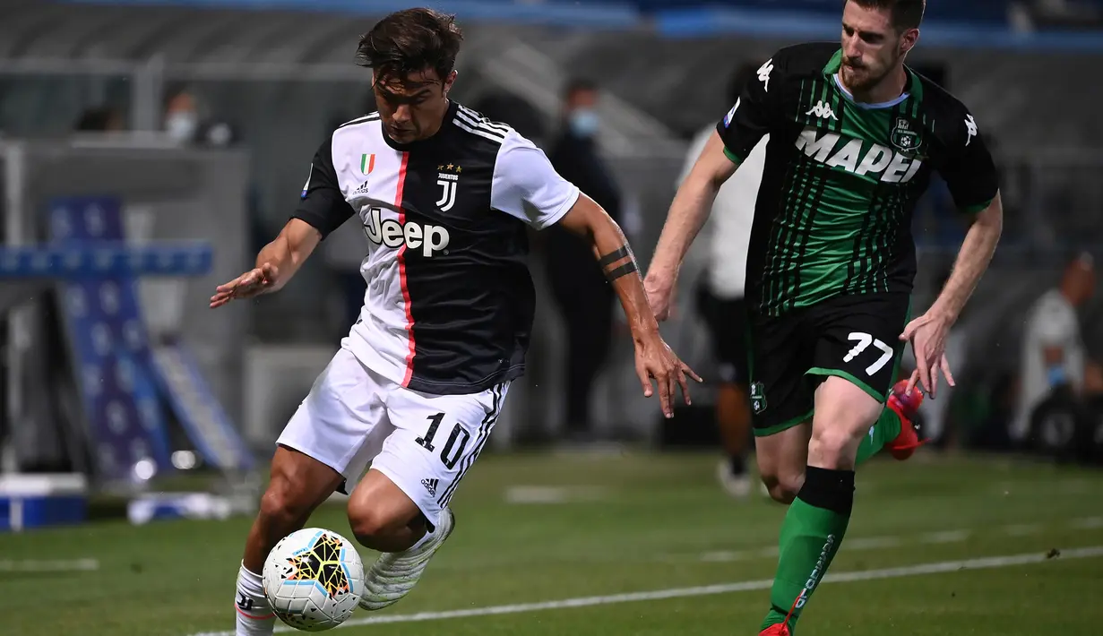 Penyerang Juventus, Paulo Dybala menggiring bola dari kejaran bek Sassuolo, Georgios Kyriakopoulos pada pertandingan lanjutan Liga Serie A Italia di stadion Mapei di Reggio Emilia (15/7/2020). Juventus bermain imbang 3-3 atas Sassuolo. (AFP/Marco Bertorello)