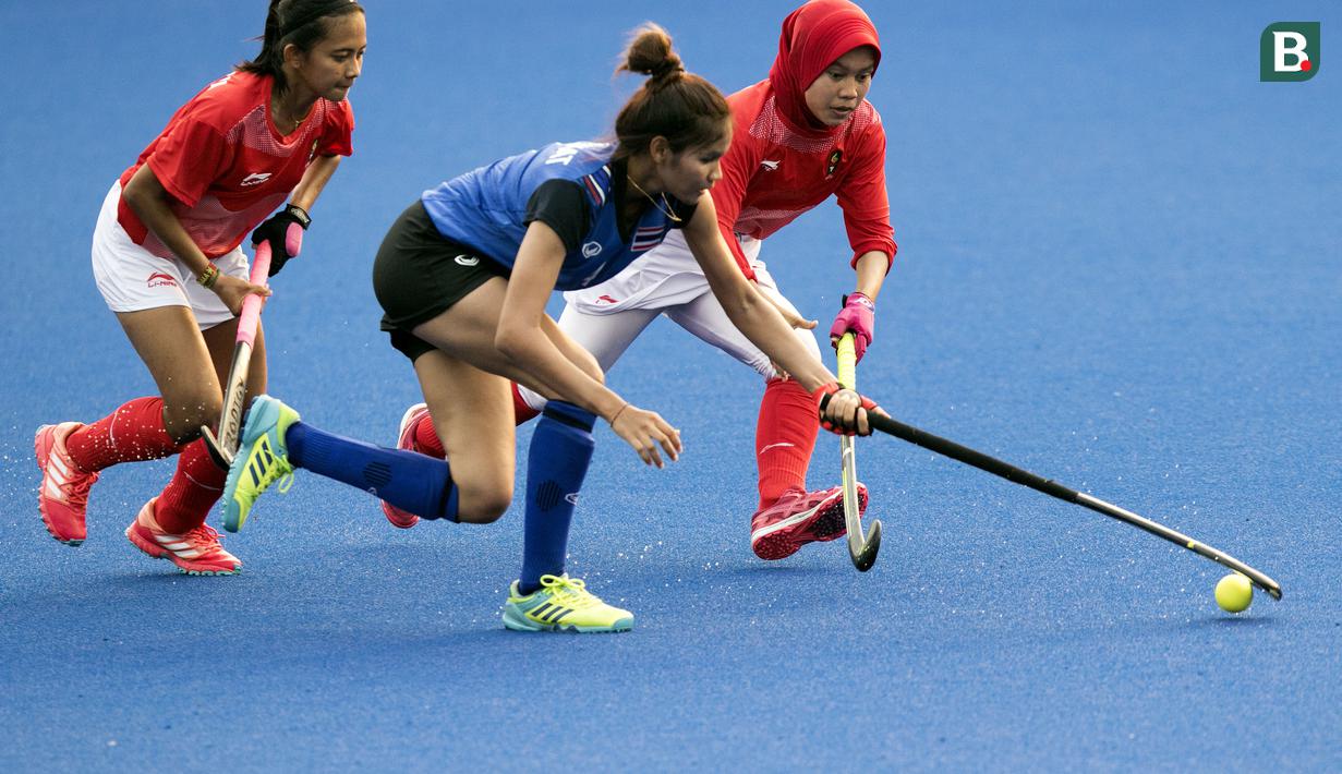 Pemain Indonesia, Yuanita Rahmadhani, berebut bola dengan pemain Thailand pada laga Asian Games di Lapangan Hoki, GBK, Jakarta, Sabtu (25/8/2018). Indonesia kalah 0-2 dari Thailand. (Bola.com/Peksi Cahyo)
