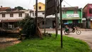 Seorang pria mengendarai becak yang membawa pelanggan melewati pohon tumbang yang tumbang di taman umum di pusat Antsirabe setelah berlalunya topan Batsirai pada 6 Februari 2022. Sedikitnya enam orang dan membuat hampir 48.000 orang mengungsi ketika Topan Batsirai melanda Madagaskar. (RIJASOLO/AFP)