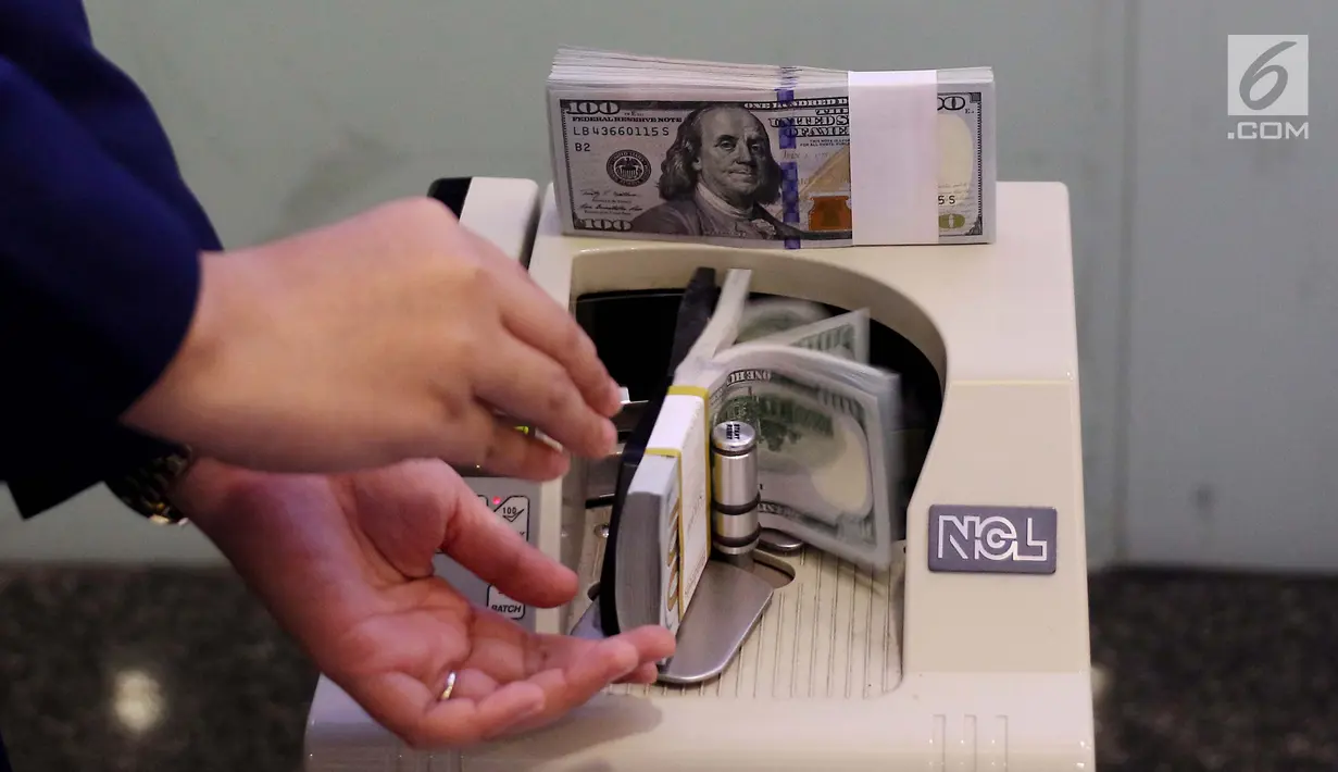 Pekerja bank menghitung uang dollar AS di Jakarta, Jumat (20/10). Pagi ini, Rupiah dibuka di Rp 13.509 per USD atau menguat tipis dibanding penutupan perdagangan sebelumnya di Rp 13.515 per USD. (Liputan6.com/Angga Yuniar)
