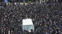 Ribuan Yahudi ultra-Ortodoks berpartisipasi dalam pemakaman rabi terkemuka Meshulam Soloveitchik, di Yerusalem, Minggu (31/1/2021). Diketahui Rabi Meshulam Dovid Soloveitchik wafat karena terpapar Covid-19. (AP Photo/Ariel Schalit)