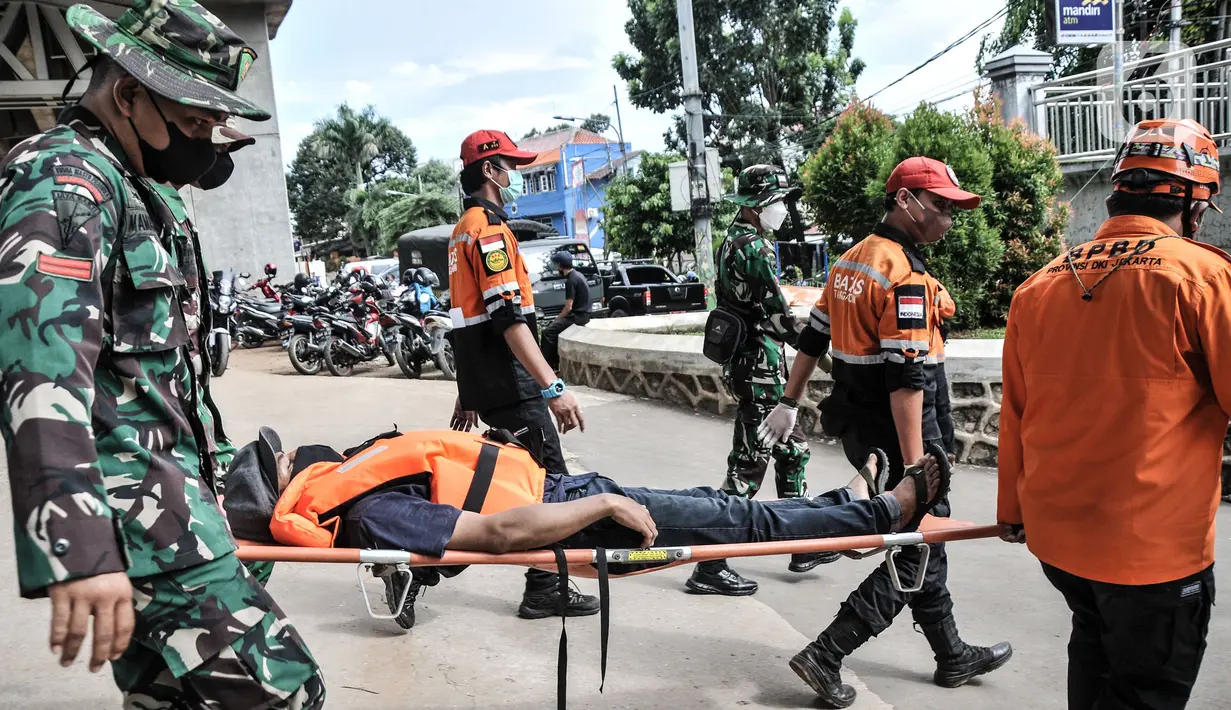 Petugas gabungan mengevakuasi korban dengan tandu saat simulasi penanganan banjir di Kalimalang, Cipinang Melayu, Rabu (17/11/2021). Simulasi digelar dalam rangka kesiapsiagaan petugas dalam penanganan korban banjir, terutama evakuasi warga yang terpapar Covid-19. (merdeka.com/Iqbal S Nugroho)