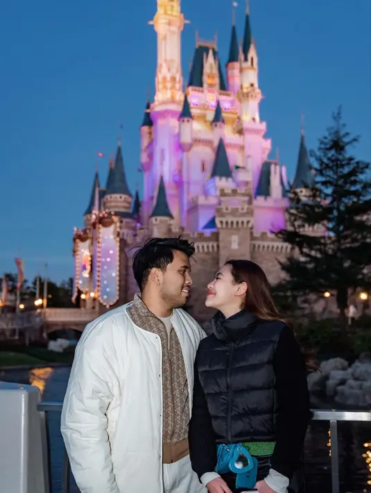 OOTD manis keduanya bermain di Disneyland. Aaliyah Massaid tampil mengenakan inner panjang berwarna putih, ditumpuknya dengan sweater lengan panjang hitam, dan puffer vest yang juga berarna hitam. Sedangkan Thariq tampil dengan kaus cokelat, ditumpuknya mengenakan jaket bermotif brand, dan puffer jacket putih sebagai outer. [Foto: Instagram/aaliyah.massaid]
