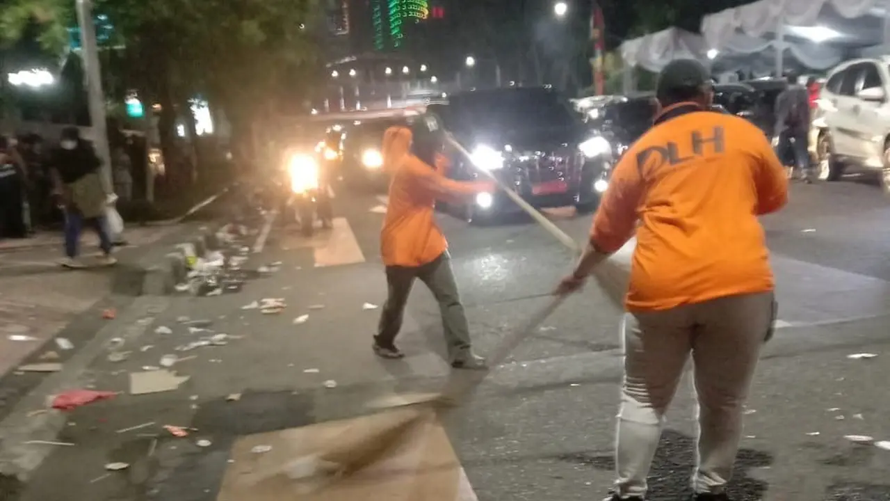Petugas membersihkan sampah bekas acara Surabaya Vaganza. (Dian Kurniawan/Liputan6.com).
