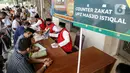 Umat muslim membayar zakat fitrah kepada amil zakat di Masjid Istiqlal, Jakarta, Jumat (7/5/2021). Panitia Zakat Masjid Istiqlal mulai membuka layanan pembayaran zakat fitrah dengan pembayaran senilai Rp 50 ribu atau 3,5 liter beras. (Liputan6.com/Faizal Fanani)