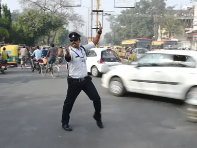 Polisi lalu lintas India Ranjeet Singh mengarahkan lalu lintas di persimpangan Indore, India (22/12). Saat mengatur lalu lintas, Ranjeet Singh menari moonwalk ala Michael Jackson yang menjadi perhatian warga sekitar.  (AFP Photo/Indranil Mukherjee)