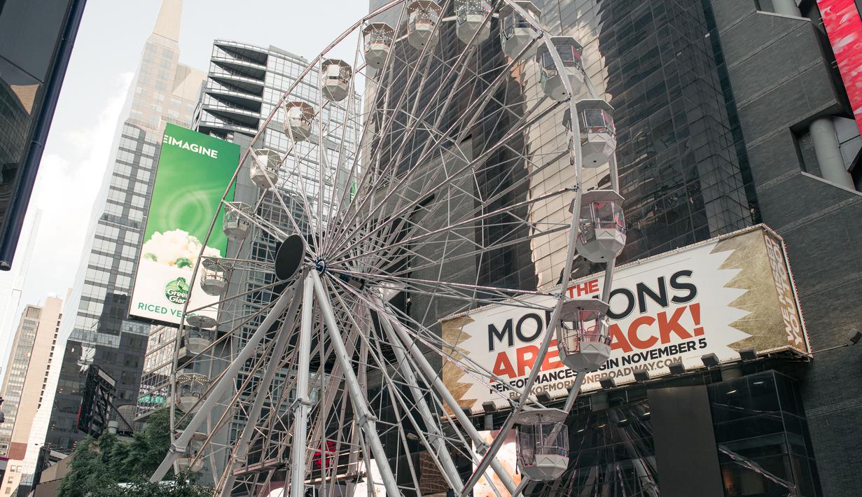 Biangalala setinggi 110 kaki yang baru dibuka berputar di Times Square, Manhattan, New York City, Rabu (25/8/2021). Kincir ria yang dibuka dengan waktu terbatas itu menawarkan pemandangan kota yang baru kepada wisatawan dan warga. (Scott Heins/Getty Images/AFP)