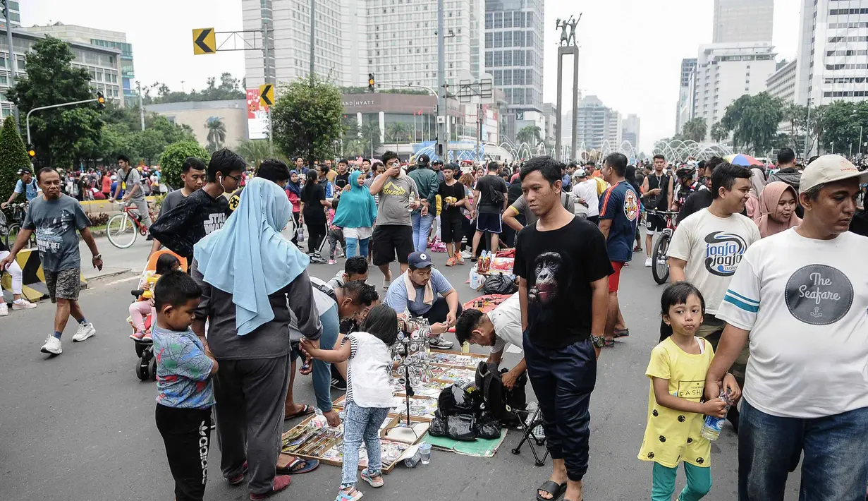 Pedagang Kaki Lima (PKL) berjualan selama kegiatan Car Free Day (CFD) di sepanjang Jalan Sudirman, Jakarta, Minggu (9/12). Kurangnya pengawasan menyebabkan banyak PKL yang berjualan tidak pada tempatnya dan memenuhi area CFD. (Liputan6.com/Faizal Fanani)