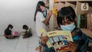 Anak-anak membaca buku saat PPKM Level 3 di Taman Baca Masyarakat Pekan Karya,  Tangerang Selatan, Banten, Selasa (8/2/2022). Pemerintah daerah di wilayah aglomerasi Jabodetabek akhirnya bisa menghentikan proses PTM setelah ditetapkan sebagai daerah berstatus PPKM level 3. (Liputan6.com/Johan Tallo)