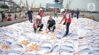 Direktur Utama Perum Bulog Budi Waseso (kiri) bersama Menteri Perdagangan Zulkifli Hasan (tengah) saat meninjau aktivitas bongkar muat beras impor di Pelabuhan Tanjung Priok, Jakarta, Jumat (16/12/2022). Perum Bulog mendatangkan 5.000 ton beras impor asal Vietnam guna menambah cadangan beras pemerintah (CBP) yang akan digunakan untuk operasi pasar. (Liputan6.com/Faizal Fanani)
