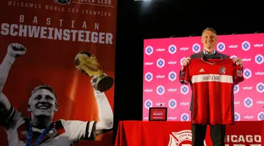 Pemain baru Major League Soccer Chicago Fire (MLS), Bastian Schweinsteiger menunjukan jerseynya saat konferensi pers di The PrivateBank Fire Pitch di Chicago, Rabu (29/3). (AP Photo/Nam Y. Huh)