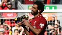 Penyerang Liverpool, Mohamed Salah, mengankat trofi Sepatu Emas Premier League usai laga melawan Brighton & Hove Albion di Stadion Anfield, Minggu (13/5/2018). Salah menjadi top scorer Premier League musim ini dengan raihan 32 gol. (AFP/Paul Ellis)