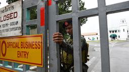 Polisi pasukan khusus berdiri di gerbang sebuah penjara di Filipina usai insiden kerusuhan, Rabu (28/9). Satu anggota geng narkoba tewas dan tiga napi terluka dalam kerusuhan di penjara yang terkenal dengan kekerasan dan kekejamannya. (TED Aljibe/AFP)