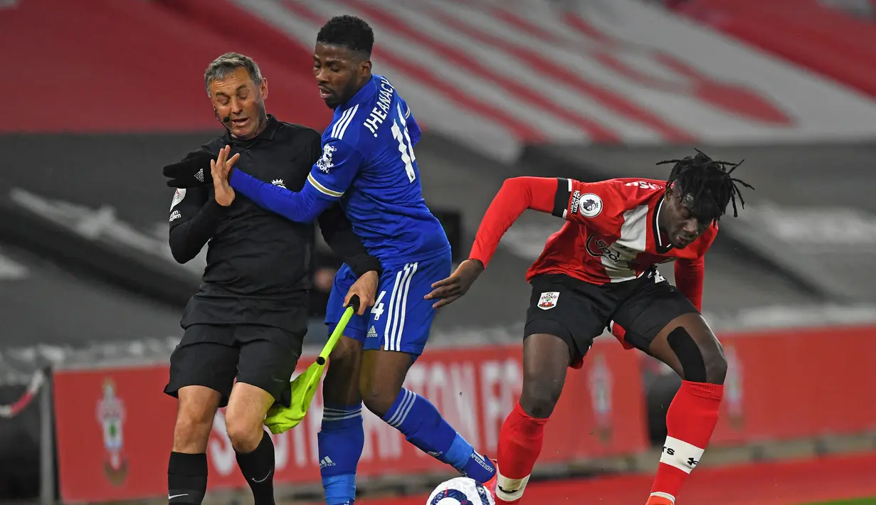 Striker Leicester City, Kelechi Iheanacho (tengah) bertabrakan dengan asisten wasit saat melawan Southampton dalam laga lanjutan Liga Inggris 2020/2021 pekan ke-34 di St Mary's Stadium, Southampton, Jumat (30/4/2021). Leicester bermain imbang 1-1 dengan Southampton. (AFP/Neil Hall/Pool)