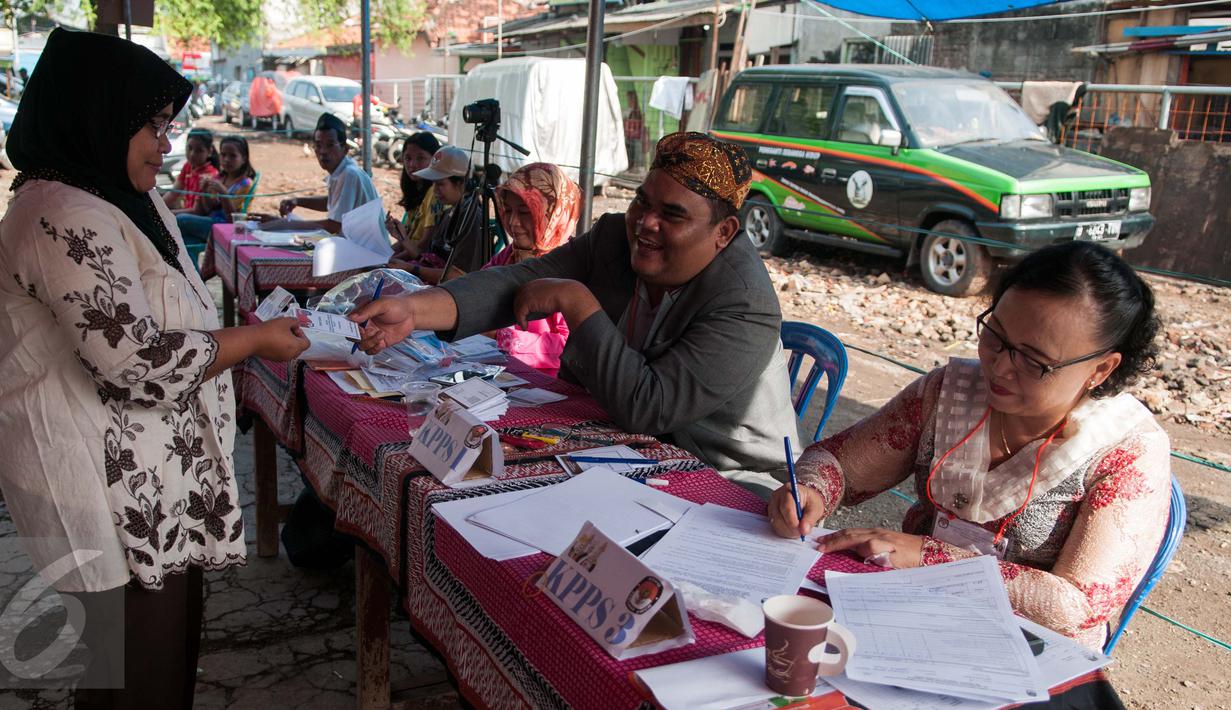 Petugas KPPS mengenakan pakaian adat dan belangkon melayani warga untuk menggunakan hak pilih di TPS 14 Cipinang Besar Selatan, Jakarta, Rabu (19/4). (Liputan6.com/Gempur M. Surya)
