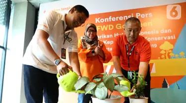 Director & Chief of Proposition & Sharia Officer FWD Life Ade Bungsu (kiri) dan Direktur Human Capital & Legal WWF-Indonesia, Apin Aviyan (kanan) menyiram pohon pada kampanye Go Green di Jakarta, Rabu (4/12/2019). Kampanye Go Green membantu nasabah memahami manfaat di balik e-Policy. (Liputan6.com)