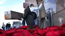 Seorang muslim bersiap membagikan bunga mawar kepada pejalan kaki di London Bridge, Minggu (11/6). Muslim Inggris membagikan ratusan mawar sebagai bentuk solidaritas menyusul serangan teror London yang terjadi pekan lalu. (Ben STANSALL/AFP)
