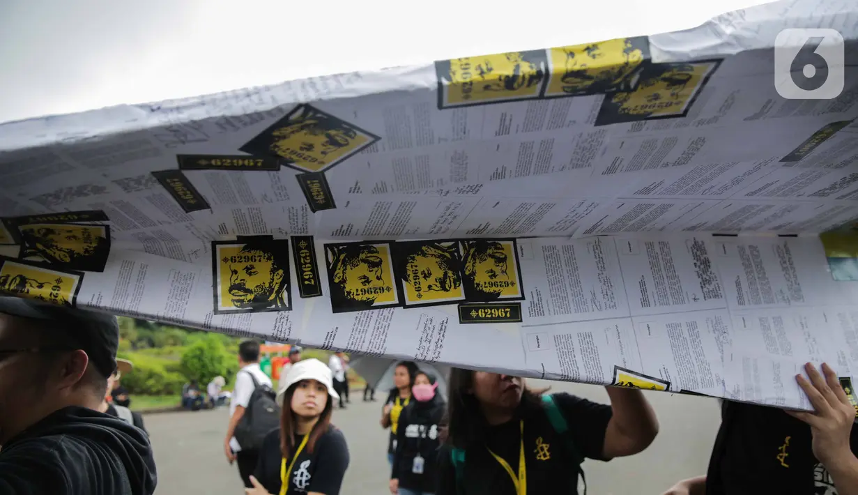 Aktivis yang tergabung dalam Amnesty Internasional Indonesia membawa replika pesawat saat menggelar aksi di depan Istana Negara, Jakarta, Selasa (10/12/2019). Replika pesawat kertas berbalut surat-surat aspirasi tersebut sebagai harapan agar keadilan bisa dipenuhi. (Liputan6.com/Faizal Fanani)