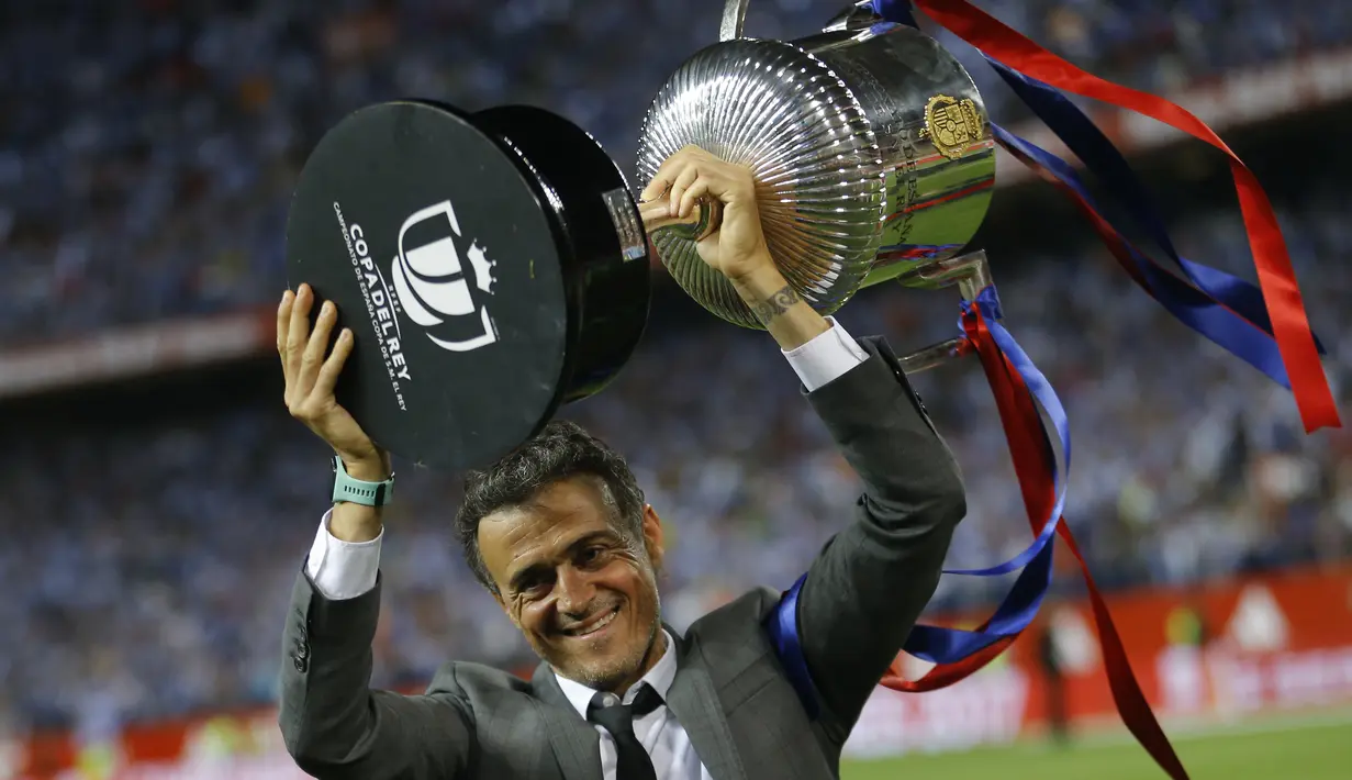 Pelatih FC Barcelona, Luis Enrique, membawa tropi Piala Raja Spanyol (Copa del Rey) di stadion Vicente Calderon, Spanyol, Minggu (28/5). Enrique mengaku bahagia bisa mempersembahkan satu trofi untuk Barca pada musim ini. (AP Photo)