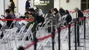 Anggota staf membantu penumpang mempersiapkan dokumen mereka selama proses karantina pencegahan virus corona mereka setelah mendarat di Bandara Internasional Narita di Narita, timur Tokyo, Jepang (2/12/2021). (AP Photo/Hiro Komae)