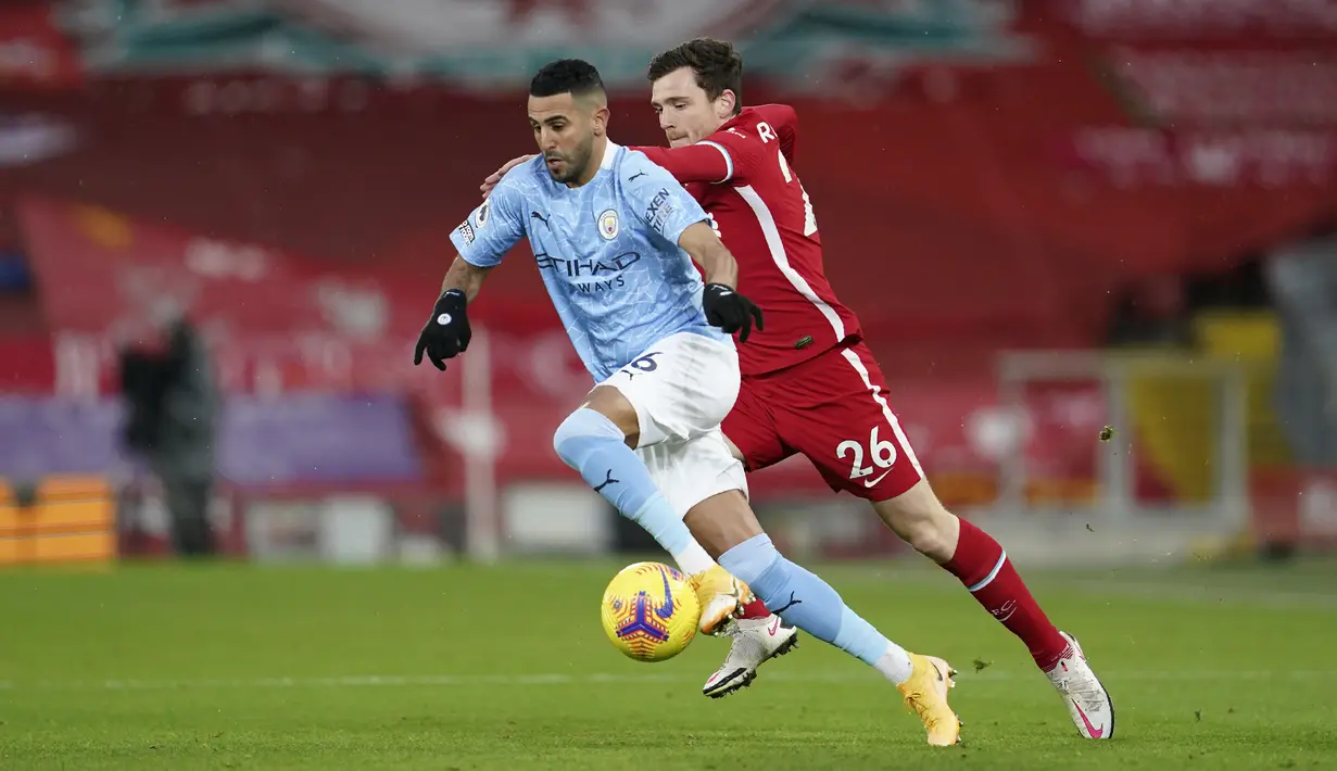 Bek Liverpool, Andrew Robertson berusaha merebut bola yang dibawa gelandang Manchester City, Riyad Mahrez pada pertandingan lanjutan Liga Inggris di Stadion Anfield, Inggris, Senin (8/2/2021).  City menang telak atas Liverpool 4-1. (AP photo/Jon Super, Pool)