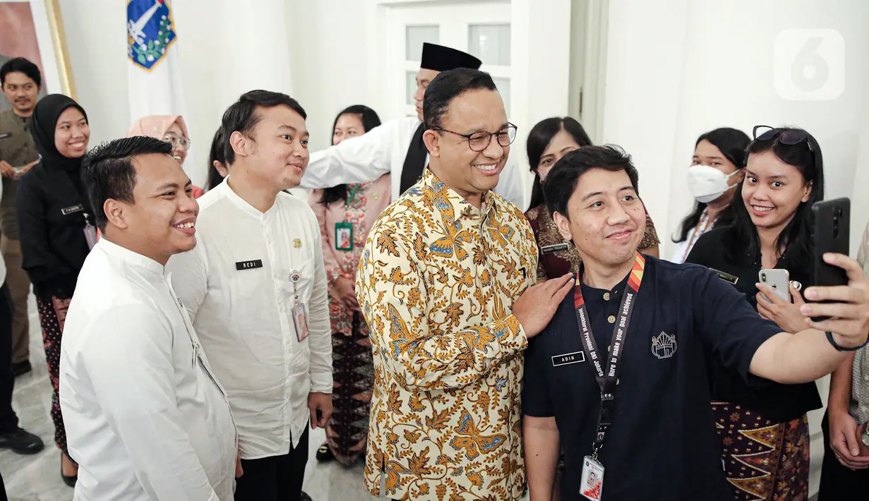 Gubernur DKI Jakarta Anies Baswedan (tengah) foto bersama Aparatur Sipil Negara (ASN) di Balai Kota DKI Jakarta, Jumat (14/10/2022). Di hari terakhir menjabat sebagai Gubernur DKI Jakarta, Anies Baswedan menyempatkan diri untuk menyapa ASN di Balai Kota. (Liputan6.com/Faizal Fanani)