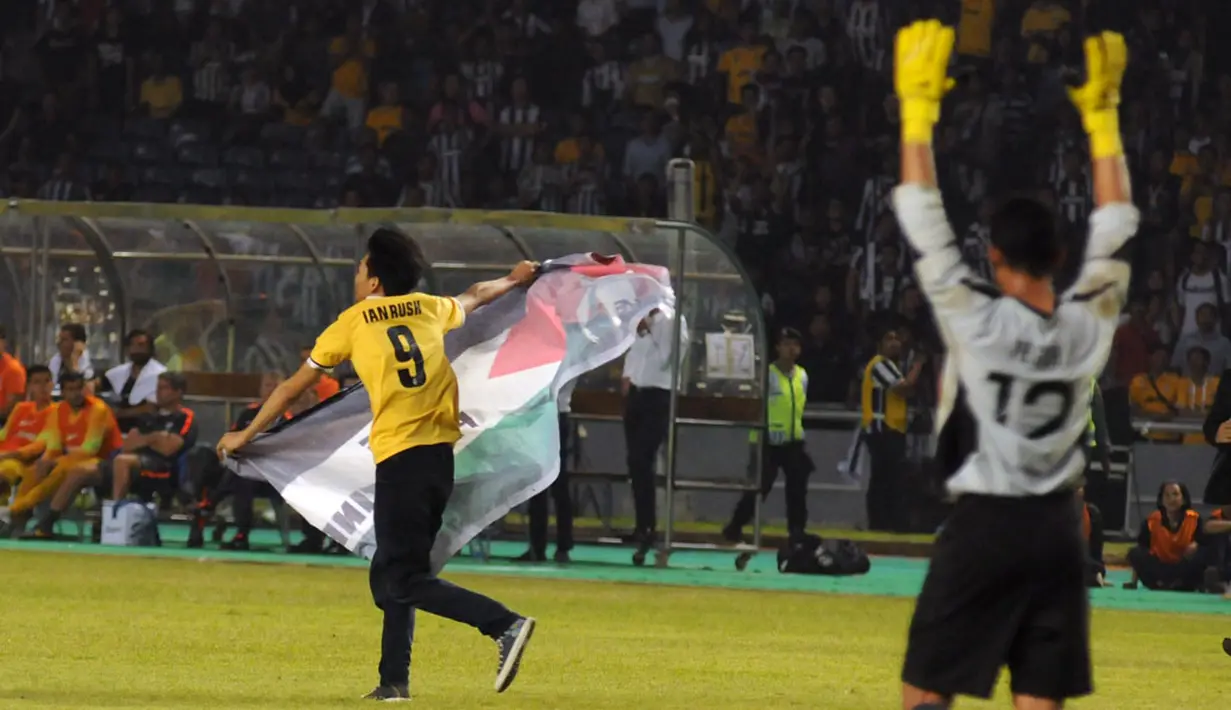 Penjaga gawang ISL All Stars, Teguh Amiruddin (kiri), mengangkat tangan meminta laga dihentikan saat salah satu suporter memasuki lapangan Stadion GBK, Jakarta, (6/8/2014). (Liputan6.com/Helmi Fithriansyah)