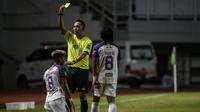 Wasit Fariq Hitaba memberikan kartu kuning kepada Penyerang Persita Tangerang, A. Nur Hardianto (kiri) saat laga pekan pertama BRI Liga 1 2021/2022 melawan Persipura Jayapura di Stadion Pakansari, Bogor, Sabtu (28/08/2021). Persita menang 2-1. (Bola.com/B