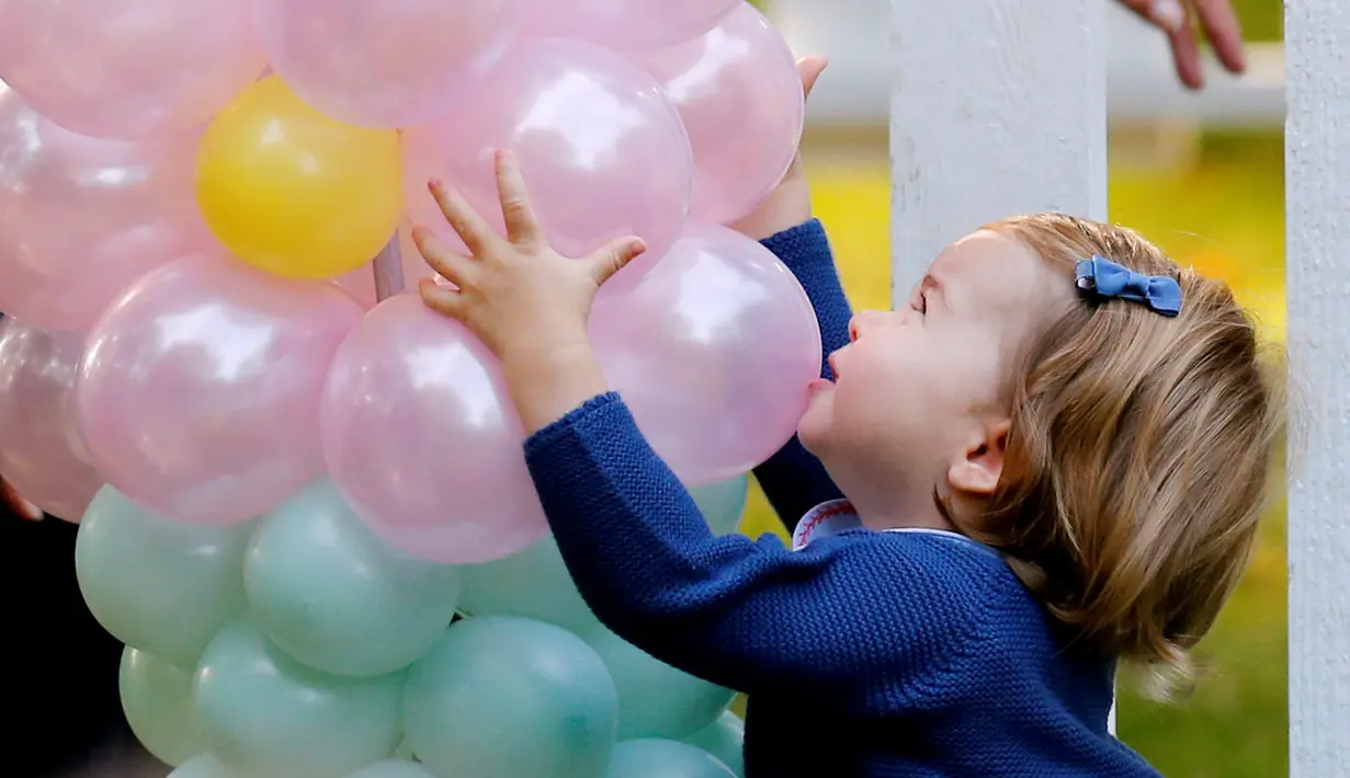 Putri Charlotte memegang balon saat menghadiri pesta anak-anak di Government House, Kanada, (29/9). Tingkah lucu putra dan putri pasangan Pangeran William dan Kate Middleton menjadi perhatian orang yang datang ke pesta tersebut. (REUTERS/Chris Wattie)