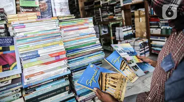 Pedagang menunjukkan buku dagangannya di kawasan Kwitang Jakarta, Jumat (26/6/2020). Sejumlah pedagang mengaku penjualan buku mengalami penurunan hingga 50 persen karena imbauan Pemerintah untuk tinggal dirumah dan libur sekolah selama pandemi COVID-19. (Liputan6.com/Faizal Fanani)