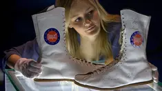 Pegawai menata sepatu boot yang dipakai dan ditandatangani oleh Muhammad Ali saat kejuaraan tinju melawan Jimmy Young pada 1975, dalam sesi pemotretan pameran tentang Ali bertajuk "I Am The Greatest", di O2 Arena, London, Kamis (3/3). (JUSTIN TALLIS/AFP)
