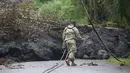 Garda Nasional Angkatan Darat AS memeriksa lahar dingin setelah letusan yang terjadi pada gunung berapi Kilauea di Hawaii (8/5). Usai letusan gunung berapi tersebut lahar dingin memenuhi jalan dan memutus lalu lintas. (Mario Tama / Getty Images / AFP)