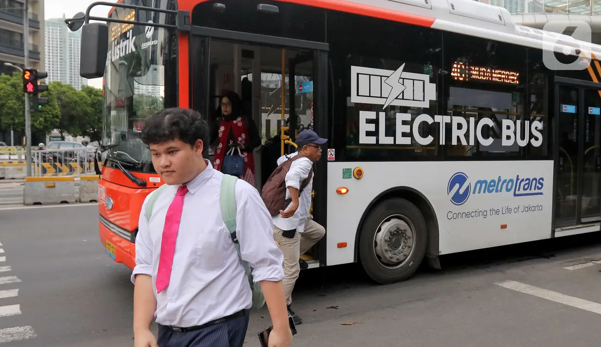 Warga berjalan dan turun dari bus Transjakarta di Jalan Jenderal Sudirman, Jakarta, Rabu (14/5/2025). (Liputan6.com/Herman Zakharia)