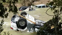 Kendaraan yang terbawa arus banjir berhenti di sungai di Waverly, Tennessee, Minggu (22/8/2021). Banjir parah yang melanda Middle Tennessee, AS, menyebabkan sedikitnya 22 orang tewas, sementara sekitar 50 orang lainnya dilaporkan masih hilang. (AP Photo/Mark Humphrey)