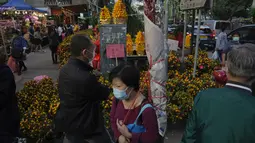 Orang-orang membeli bunga untuk merayakan Tahun Baru Imlek di Hong Kong, Rabu (19/1/2022). Tahun Baru Imlek China jatuh pada 1 Februari 2022. (AP Photo/Kin Cheung)