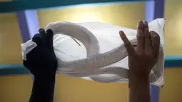 Petugas melakukan proses packing ular hidup di salah satu perusahaan eksportir di Surabaya, 13 Februari 2019. Ular-ular tersebut diekspor secara legal untuk memenuhi kebutuhan menu masakan di Guangzhou, China. (Juni Kriswanto/AFP)